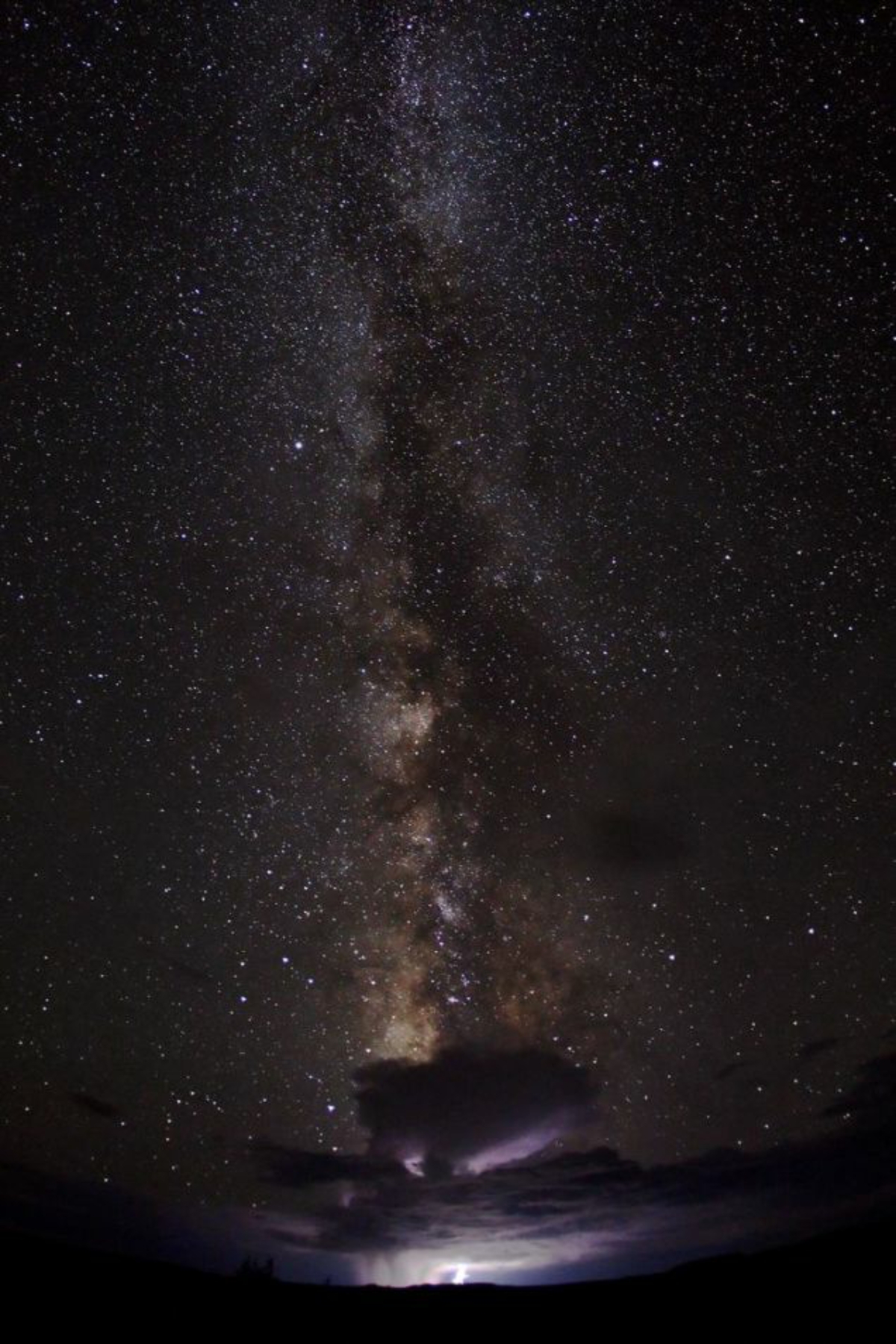 The Milky Way And Faraway Storm Embrace In This Stunning Photo!